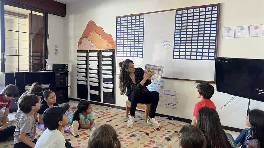 A studio circled up for the daily Socratic launch with a guide at Acton Academy El Salvador
