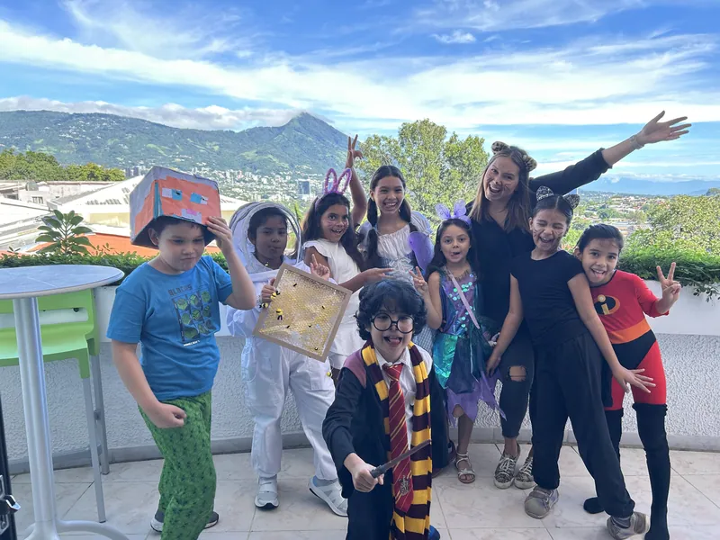 Learners in costume on the terrace with the valley behind them