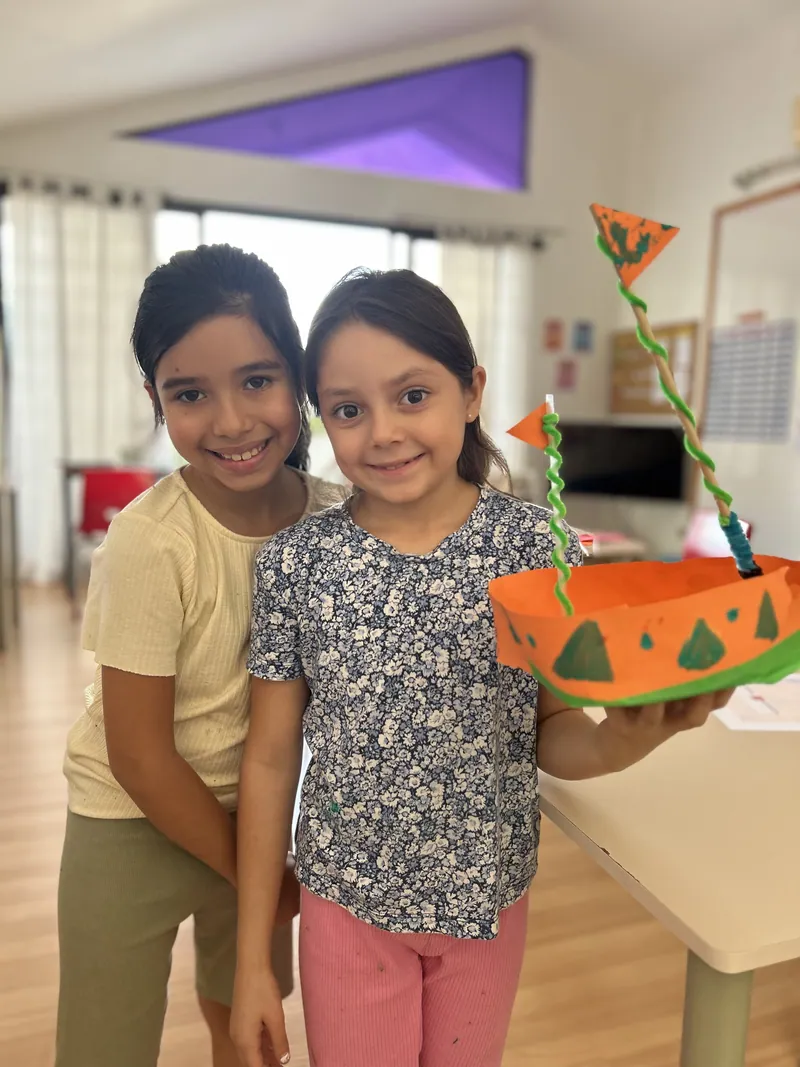 Two learners smiling with the piece they made