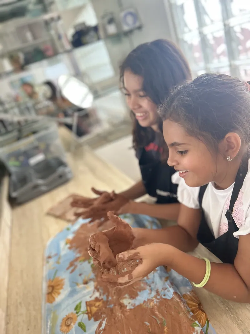 Learners shaping clay on a pottery wheel