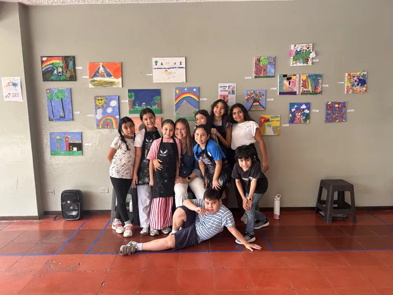Learners standing in front of a wall covered with their own artwork