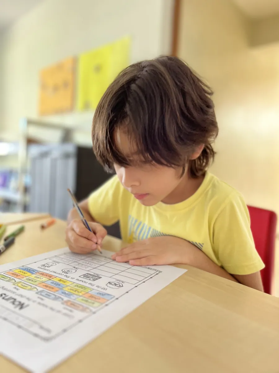 A learner concentrating on his own self directed work at Acton Academy El Salvador