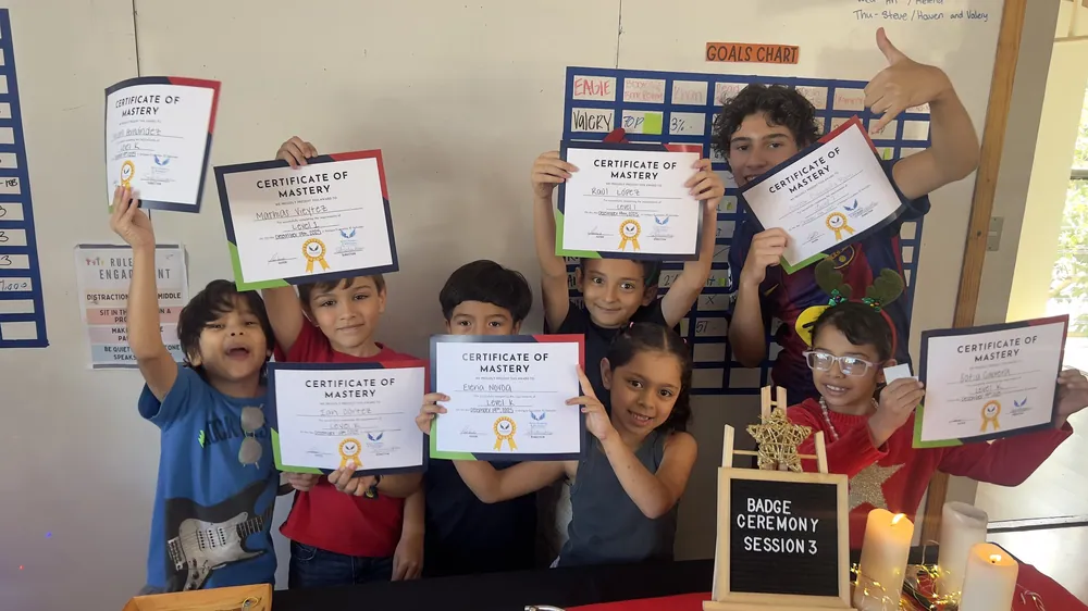 Learners at Acton Academy El Salvador holding their Certificates of Mastery at a badge ceremony