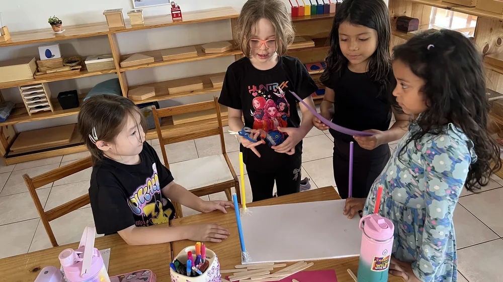 Young children working with authentic Montessori materials on open shelves at Acton Academy El Salvador